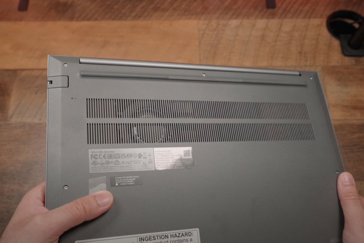 Phần đáy máy làm từ nhựa cao cấp, tích hợp hai dải lưới tản nhiệt lớn được bố trí hợp lý để hỗ trợ thoát nhiệt hiệu quả