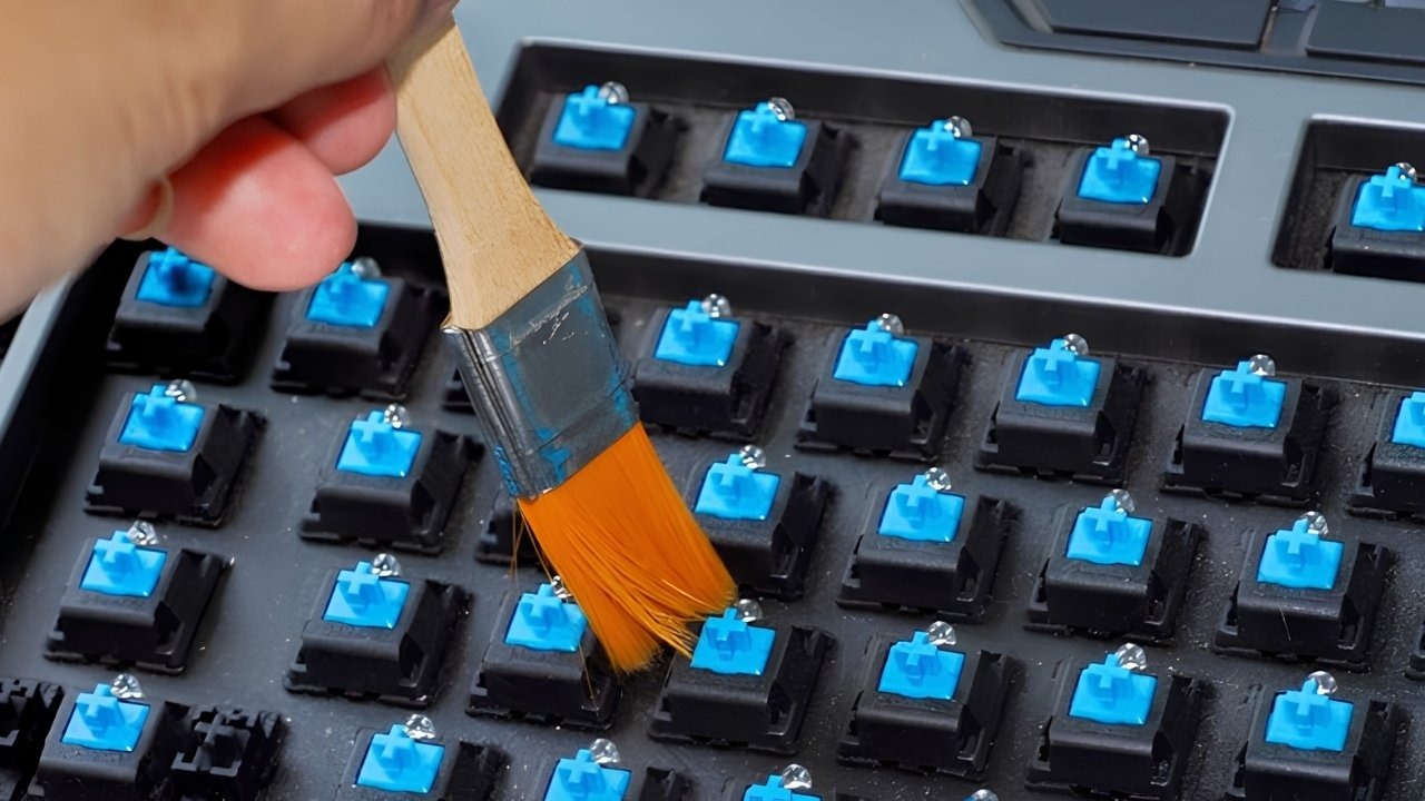Dốc ngược bàn phím, dùng bóng thổi bụi và cọ mềm để làm sạch nhẹ nhàng các khe hở phím bị kẹt